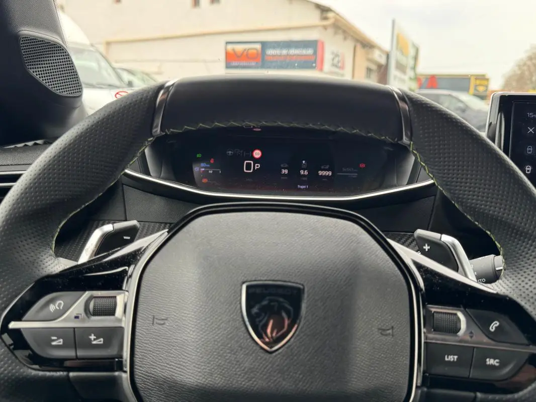 Vue rapprochée du volant multifonction noir et du tableau de bord numérique d'une Peugeot 208 Hybrid 110 gris 2025.
