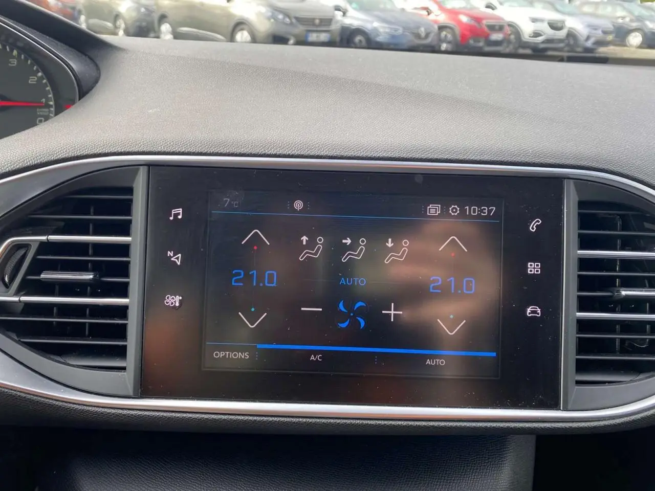 Écran tactile central de la Peugeot 308 2018 affichant la climatisation automatique bi-zone à 21°C.