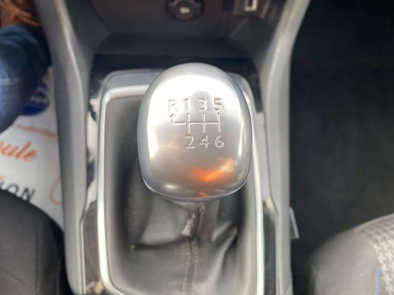 Gros plan sur le levier de vitesses manuel argenté de la Peugeot 308, entouré de sellerie noire et console centrale.