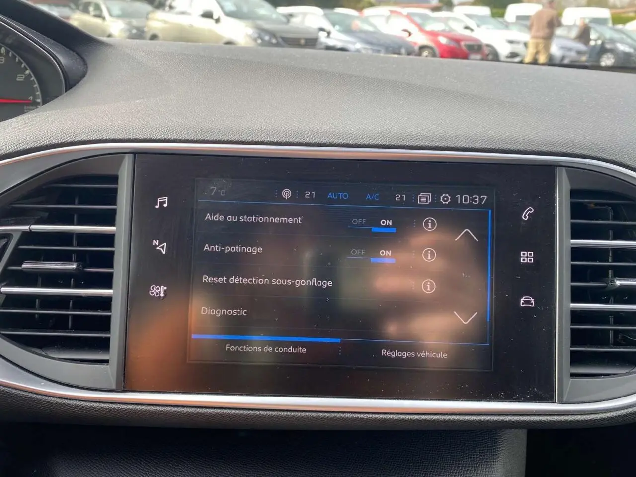 Écran tactile central de la Peugeot 308 2018 affichant les aides au stationnement et réglages de conduite.