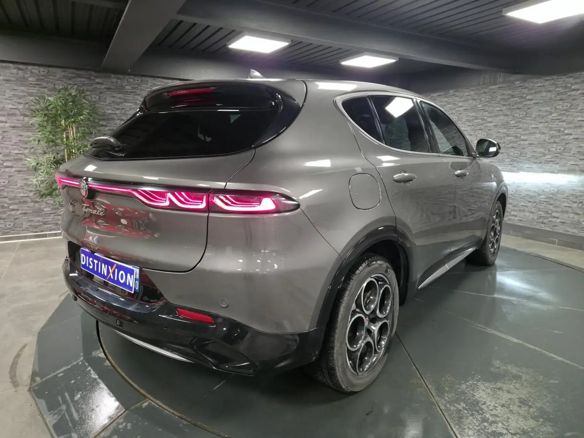 Vue 3/4 arrière droite d'une Alfa Romeo Tonale gris métallisé avec feux arrière LED et jantes alliage 18 pouces.