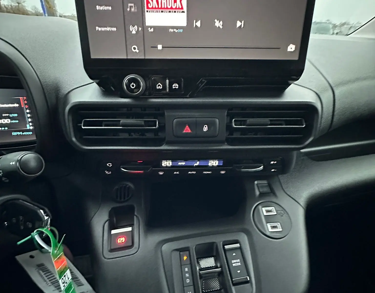 Vue intérieure du tableau de bord du Citroën Berlingo 2025, écran tactile central affichant la radio Skyrock, commandes climatisation et boîte auto.