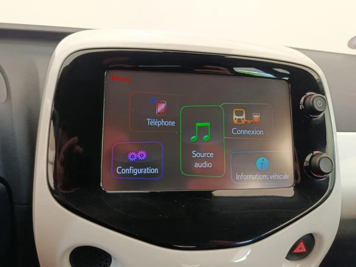 Écran tactile central de la Toyota Aygo blanc 2016 affichant menu audio et téléphone.