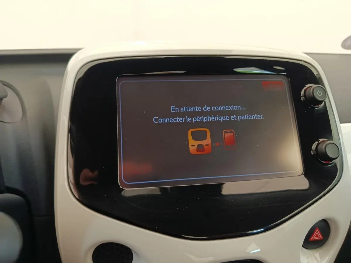 Écran tactile central blanc de la Toyota Aygo 2016 affichant un message de connexion Bluetooth en attente.