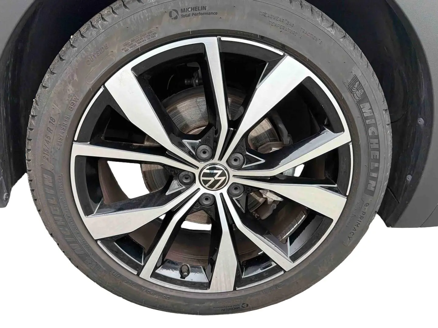 Gros plan sur la jante alliage 18 pouces bicolore noir et argent du Volkswagen T-Cross gris, pneu Michelin visible.