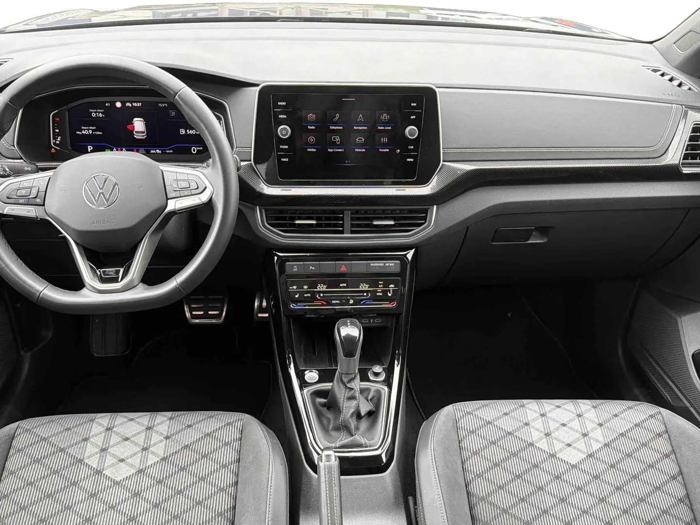Vue intérieure avant du Volkswagen T-Cross gris 2025, tableau de bord moderne avec écran tactile et boîte manuelle.