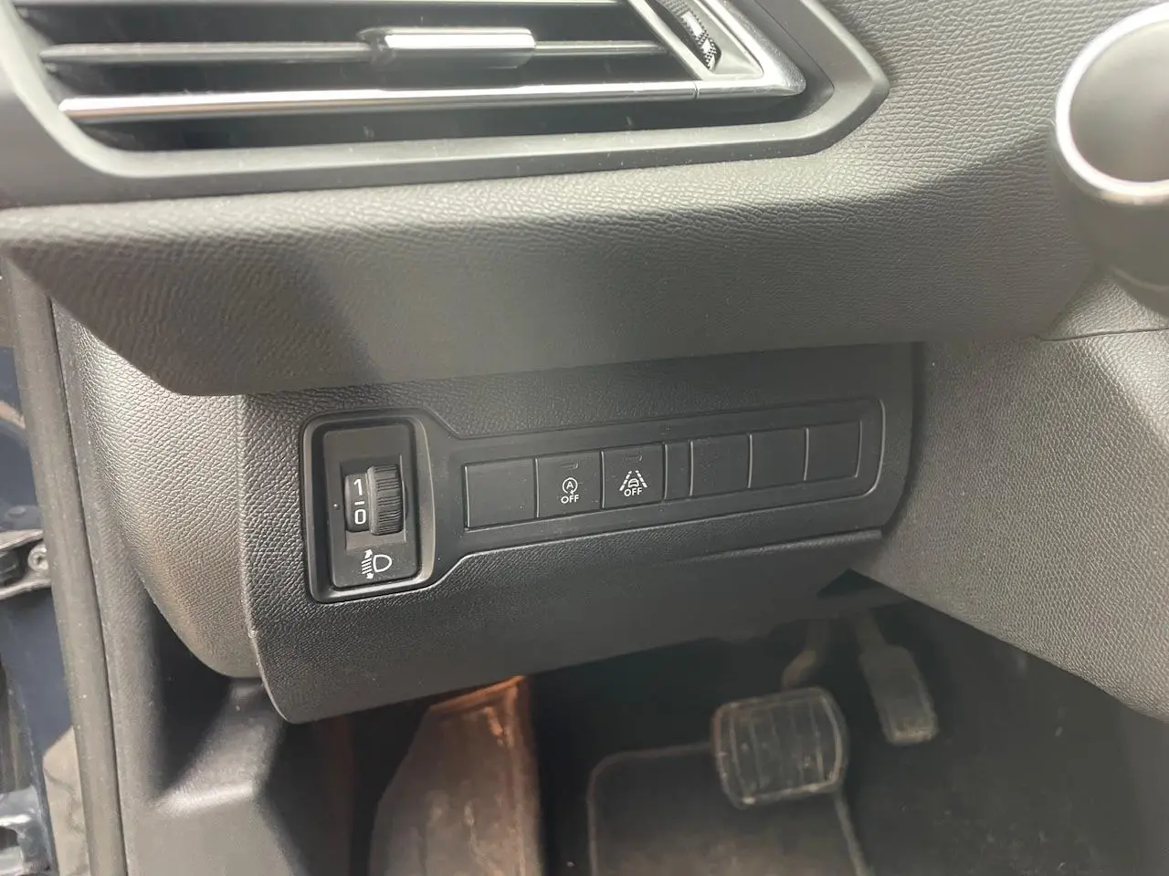 Détail intérieur montrant les commandes d'éclairage et d'assistance au conducteur sur une Peugeot 308 gris Hurricane de 2018.
