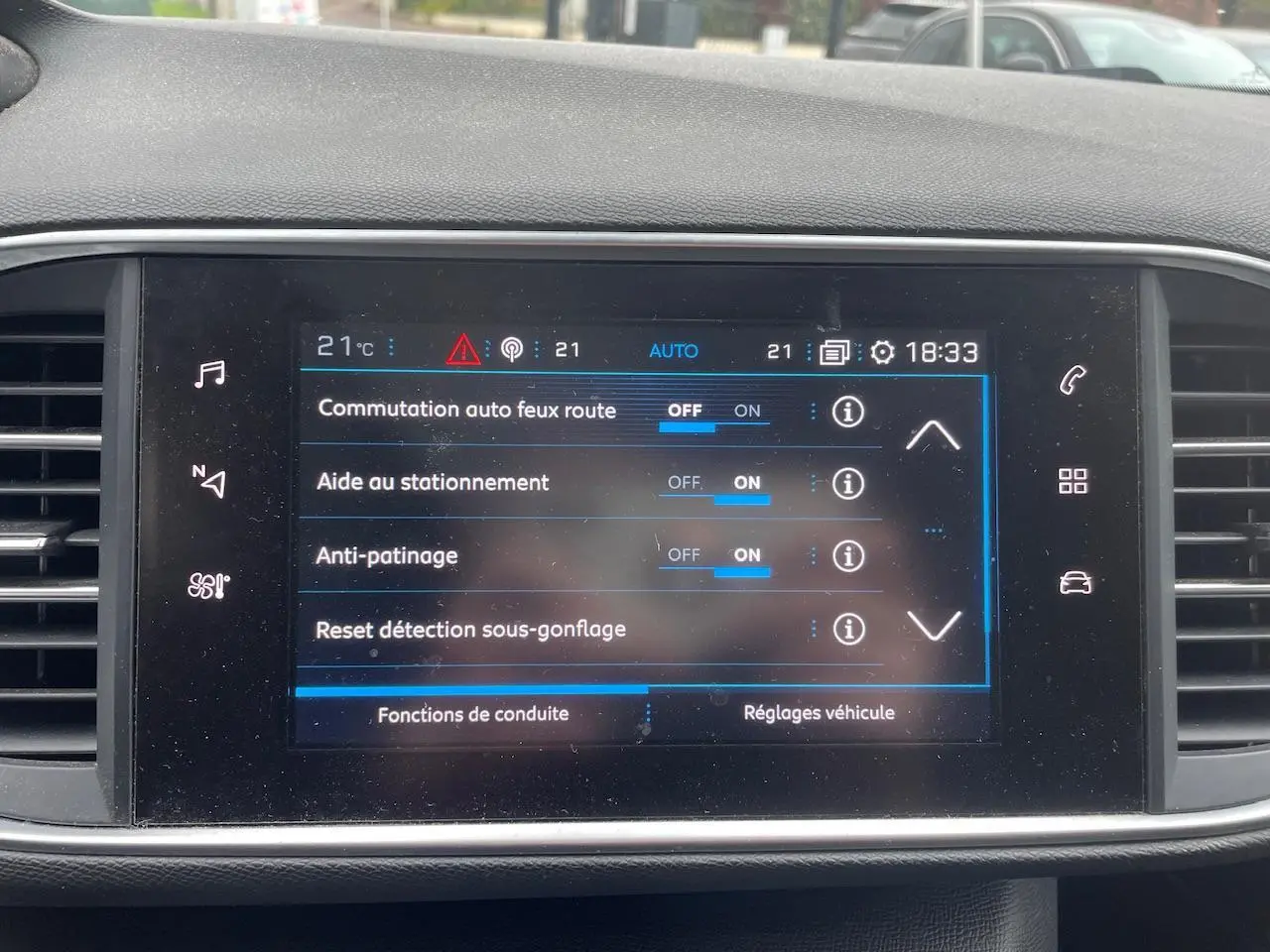 Écran tactile central de la Peugeot 308 gris Hurricane affichant les réglages d’aide à la conduite.