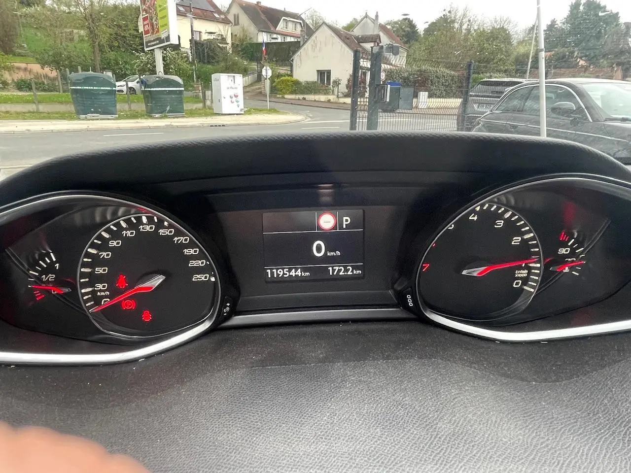 Vue rapprochée du tableau de bord de la Peugeot 308 gris hurricane, affichant le compteur et l'écran digital au repos.