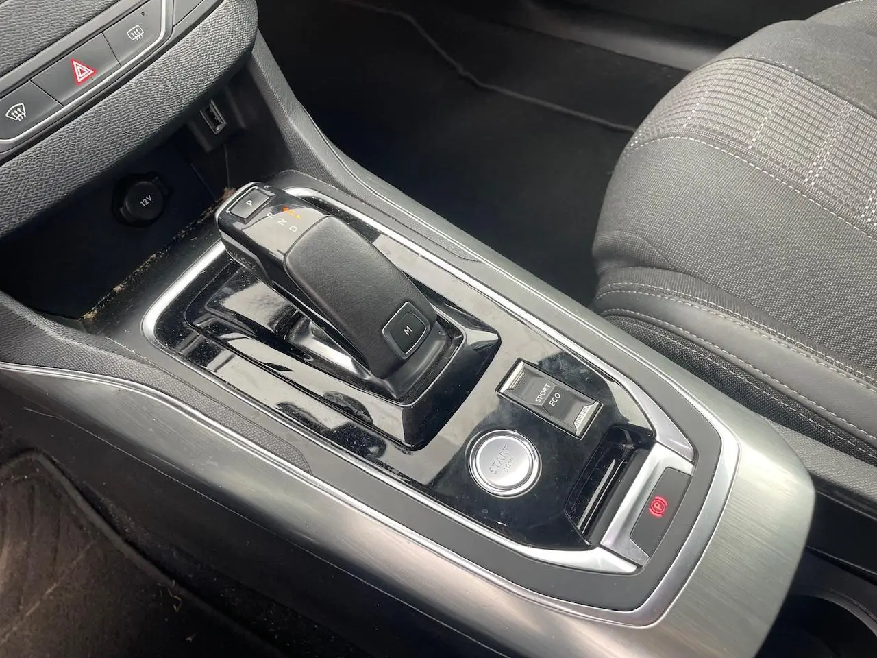 Gros plan sur la console centrale de la Peugeot 308 gris hurricane, avec levier de boîte auto et bouton start/stop.