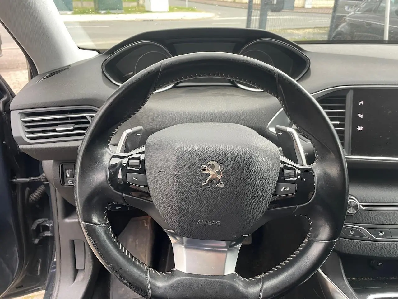 Volant en cuir noir de Peugeot 308 2018, vue frontale de l'habitacle avec tableau de bord et écran tactile visible.