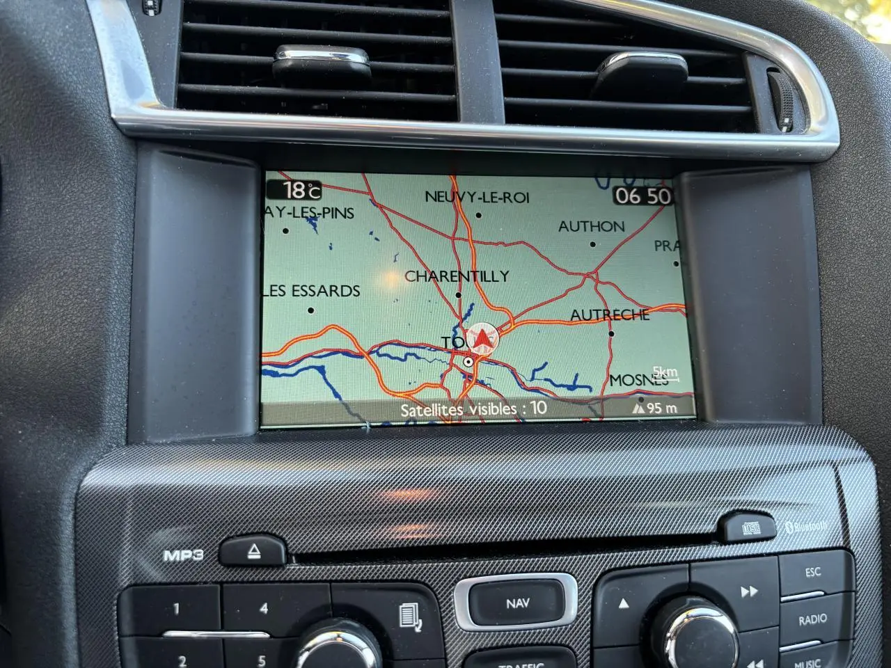 Écran de navigation eMyWay affichant une carte, intégré au tableau de bord gris clair de la Citroën C4 2012.