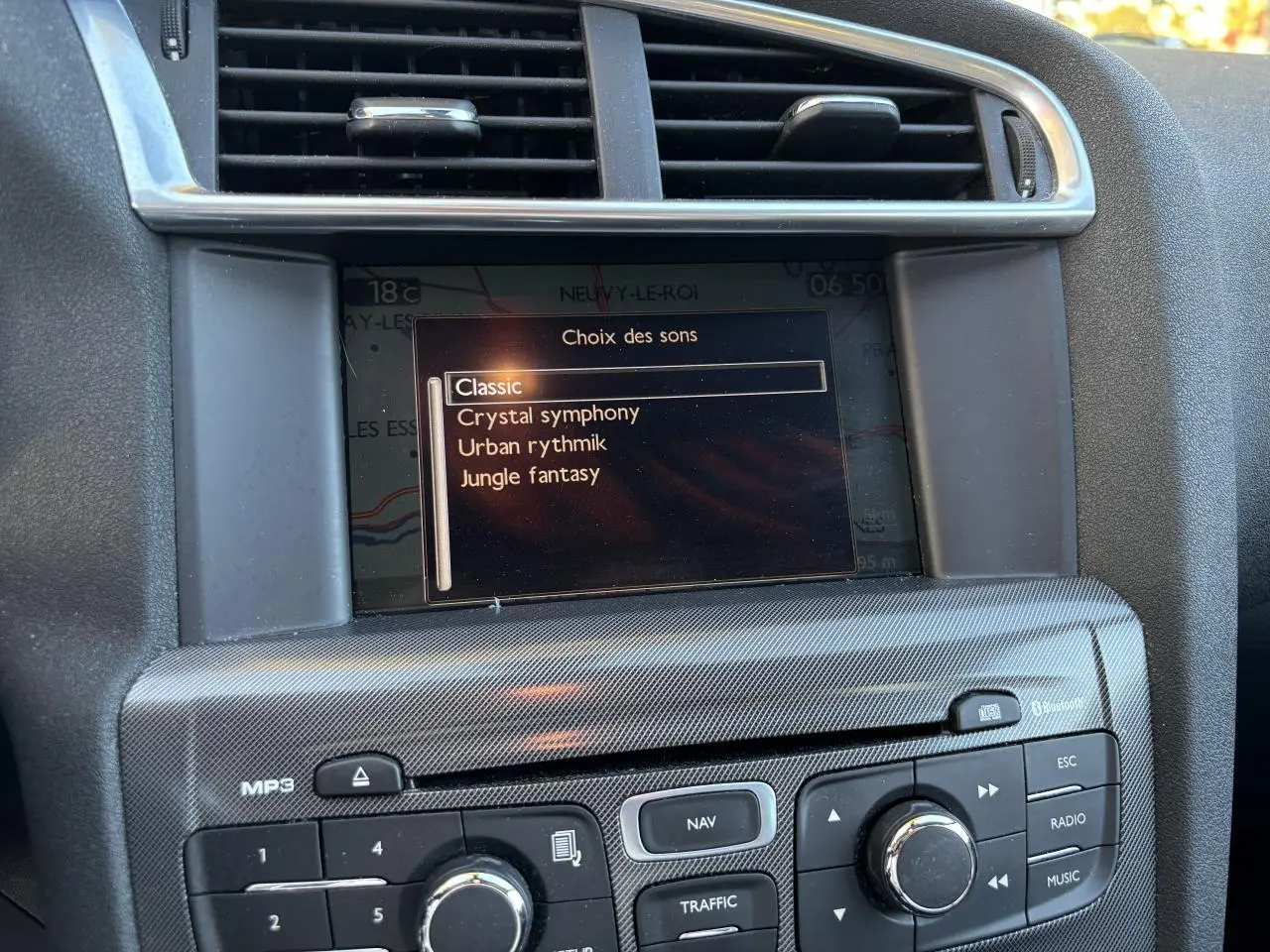 Gros plan sur l'écran de navigation eMyWay et la console centrale carbone d'une Citroën C4 gris clair de 2012.