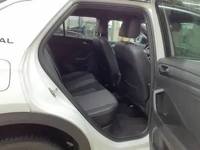 Vue intérieure arrière côté droit du Volkswagen T-Roc blanc avec toit noir, montrant les sièges arrière et l'habitacle.