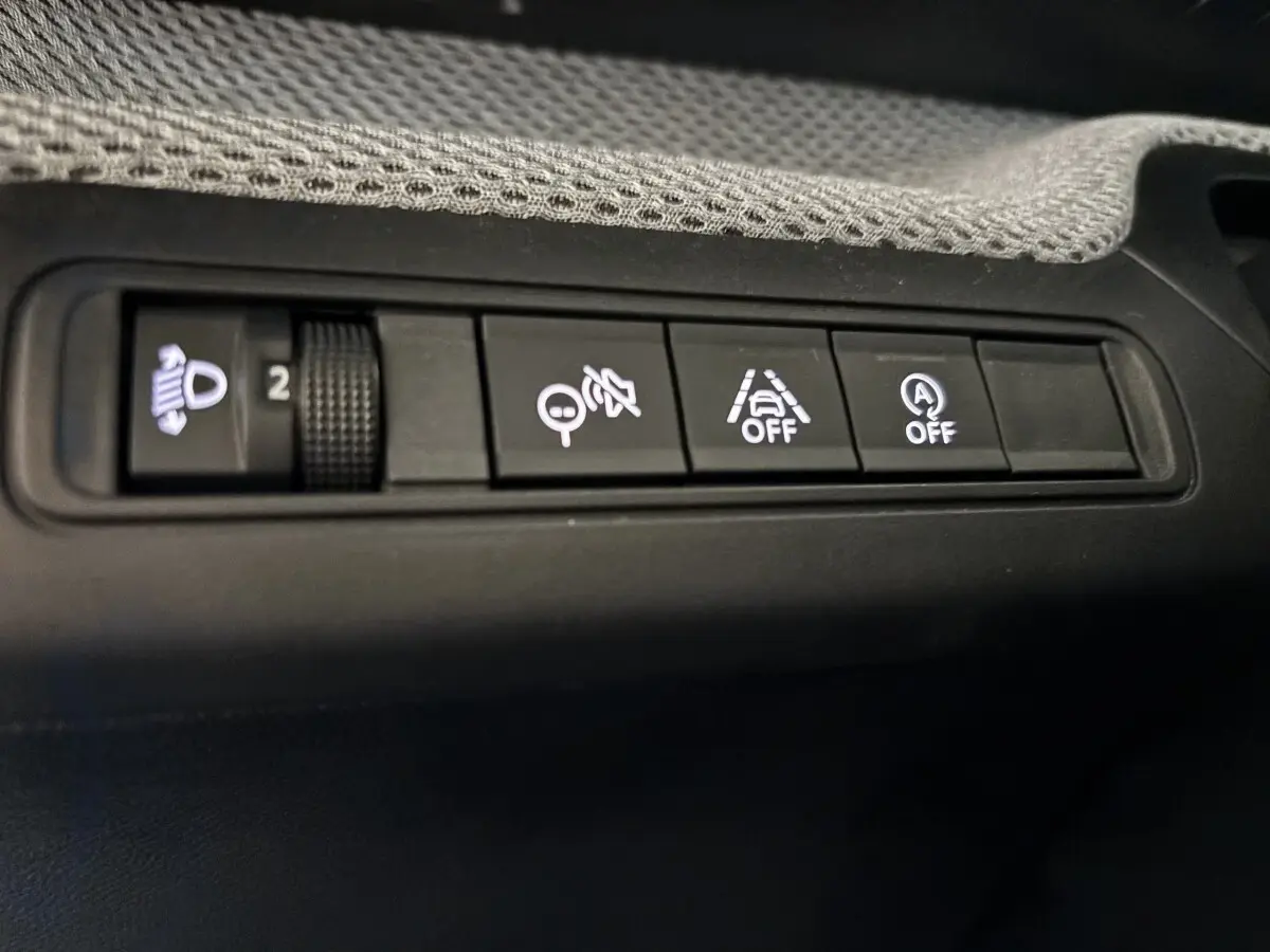 Gros plan sur les boutons de commande noirs du tableau de bord de la Citroën C3 100 BVM PLUS 2025.