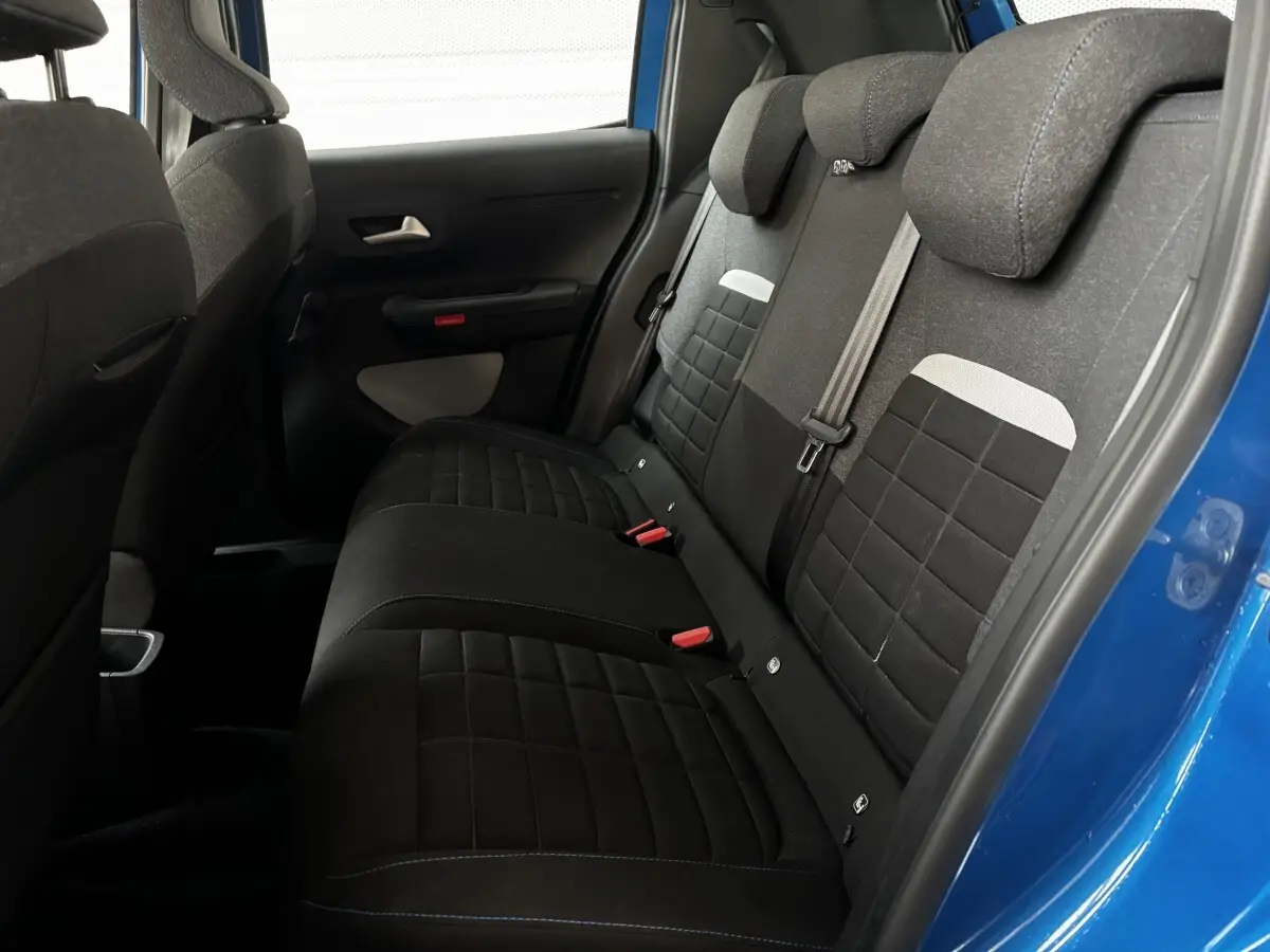 Vue intérieure côté droit des sièges arrière noirs et gris de la Citroën C3 2025 avec porte bleue ouverte.