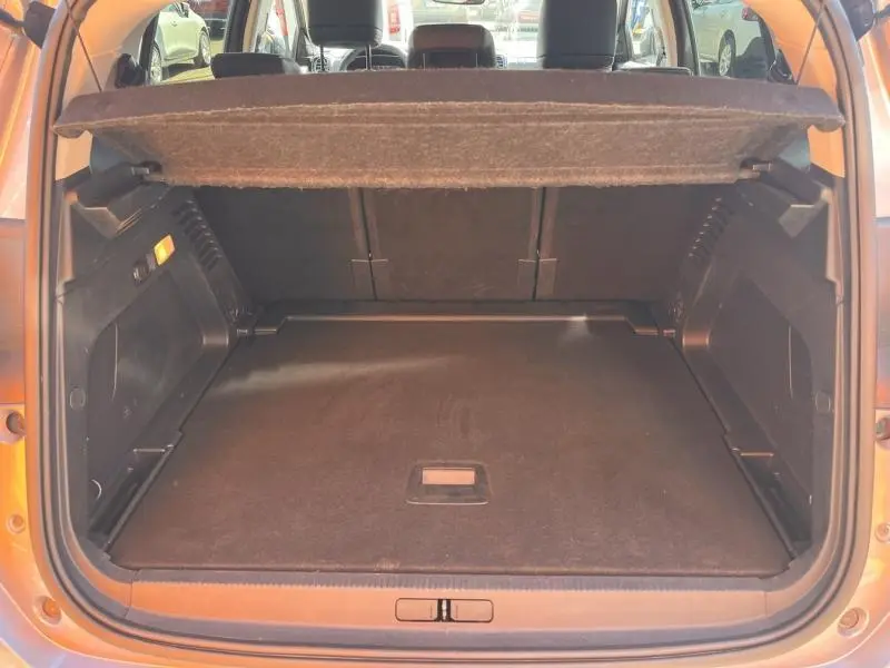 Coffre ouvert vu de l'arrière d'un Citroën C5 Aircross gris, montrant l'espace de chargement et la tablette cache-bagages.