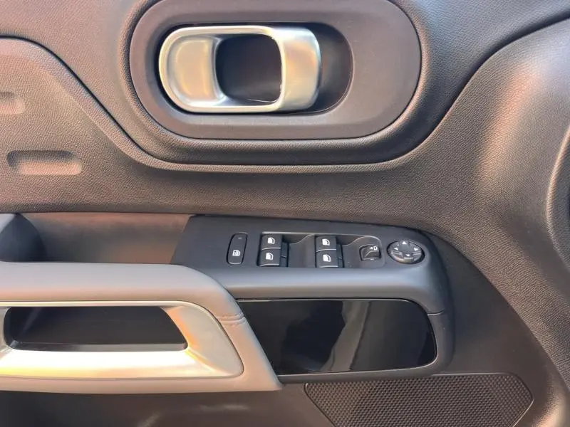 Détail de la porte côté gauche du Citroën C5 Aircross gris, avec poignée intérieure argentée et commandes des vitres électriques.
