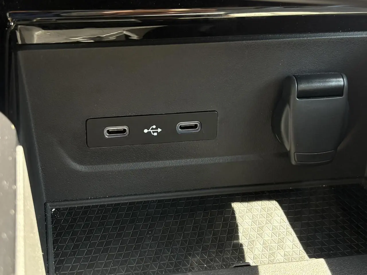 Gros plan sur la console centrale du Renault Espace VI hybride, montrant deux ports USB-C et une prise 12V noire.