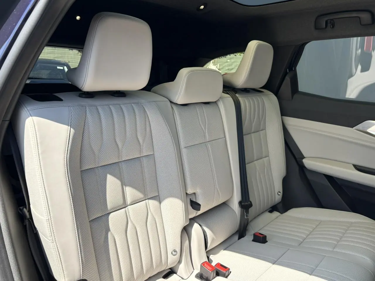 Vue latérale intérieure montrant la banquette arrière en sellerie refined gris sable clair du Renault Espace 2025.