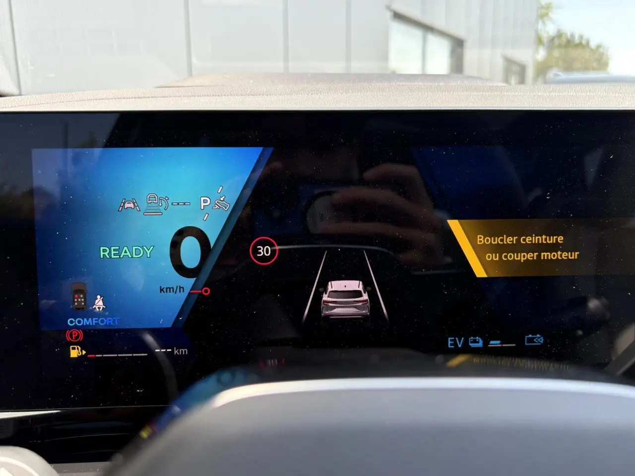 Affichage numérique du tableau de bord du Renault Espace VI hybride, montrant l'aide à la conduite et l'alerte ceinture.