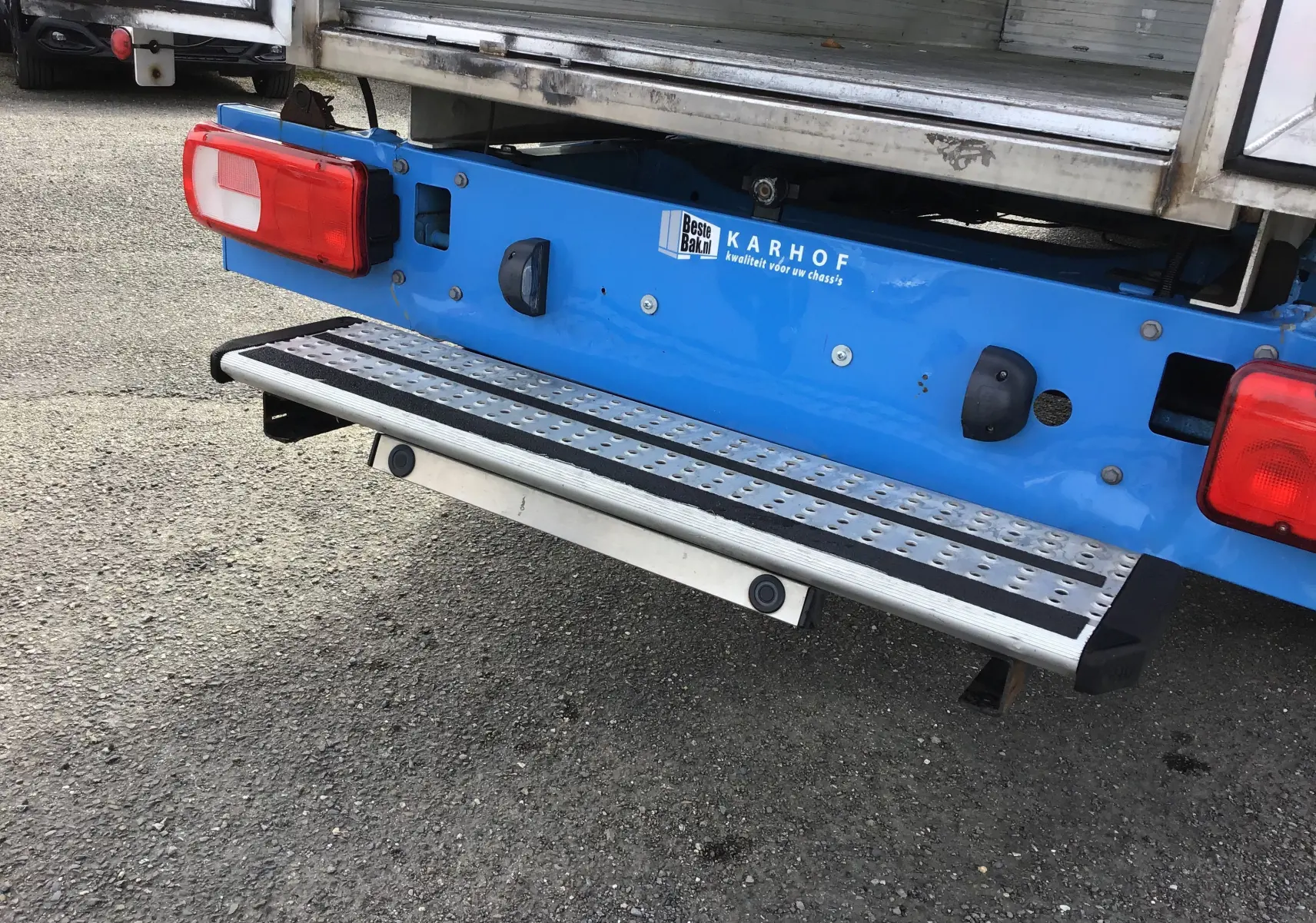 Détail de la partie arrière bleue du Volkswagen Crafter Chassis Cabine 2017 avec marchepied en aluminium et feux rouges.