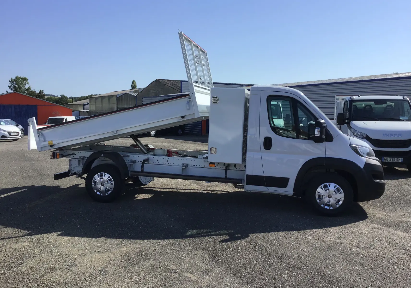 FIAT Ducato Chassis Benne blanc vu de profil côté droit, benne acier relevée et coffre latéral fermé.