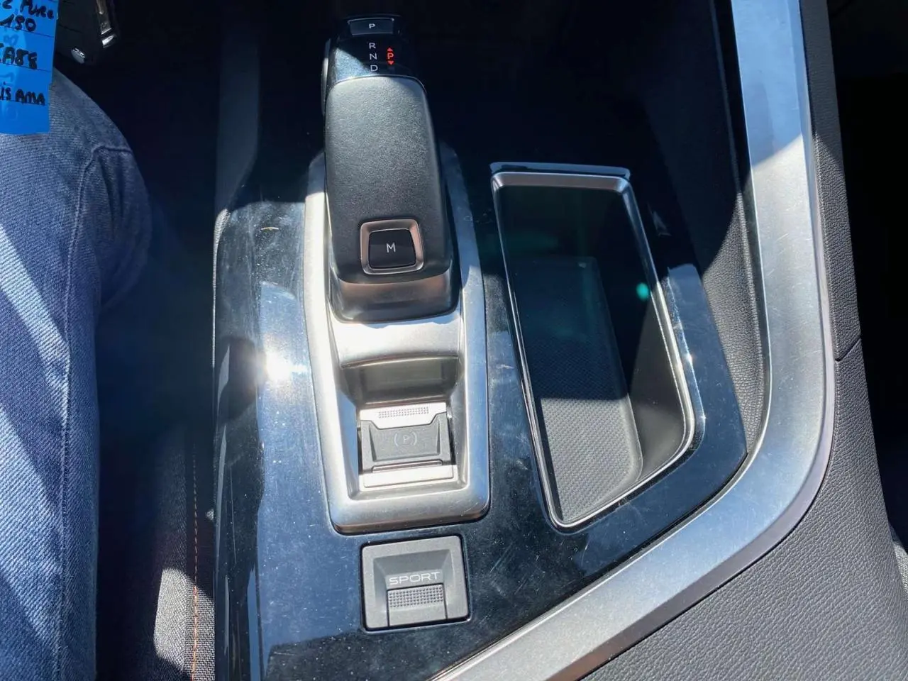 Le levier de vitesse automatique et bouton sport du Peugeot 5008 gris clair vus de dessus dans l'habitacle.