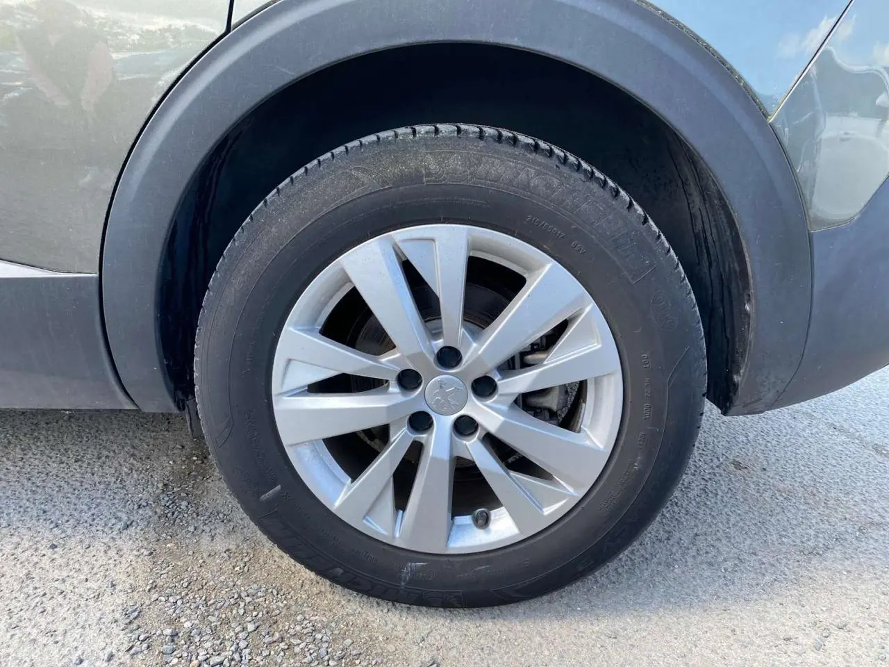 Gros plan sur la roue avant gauche gris clair du Peugeot 5008 2019 avec jante alliage à 5 branches doubles.