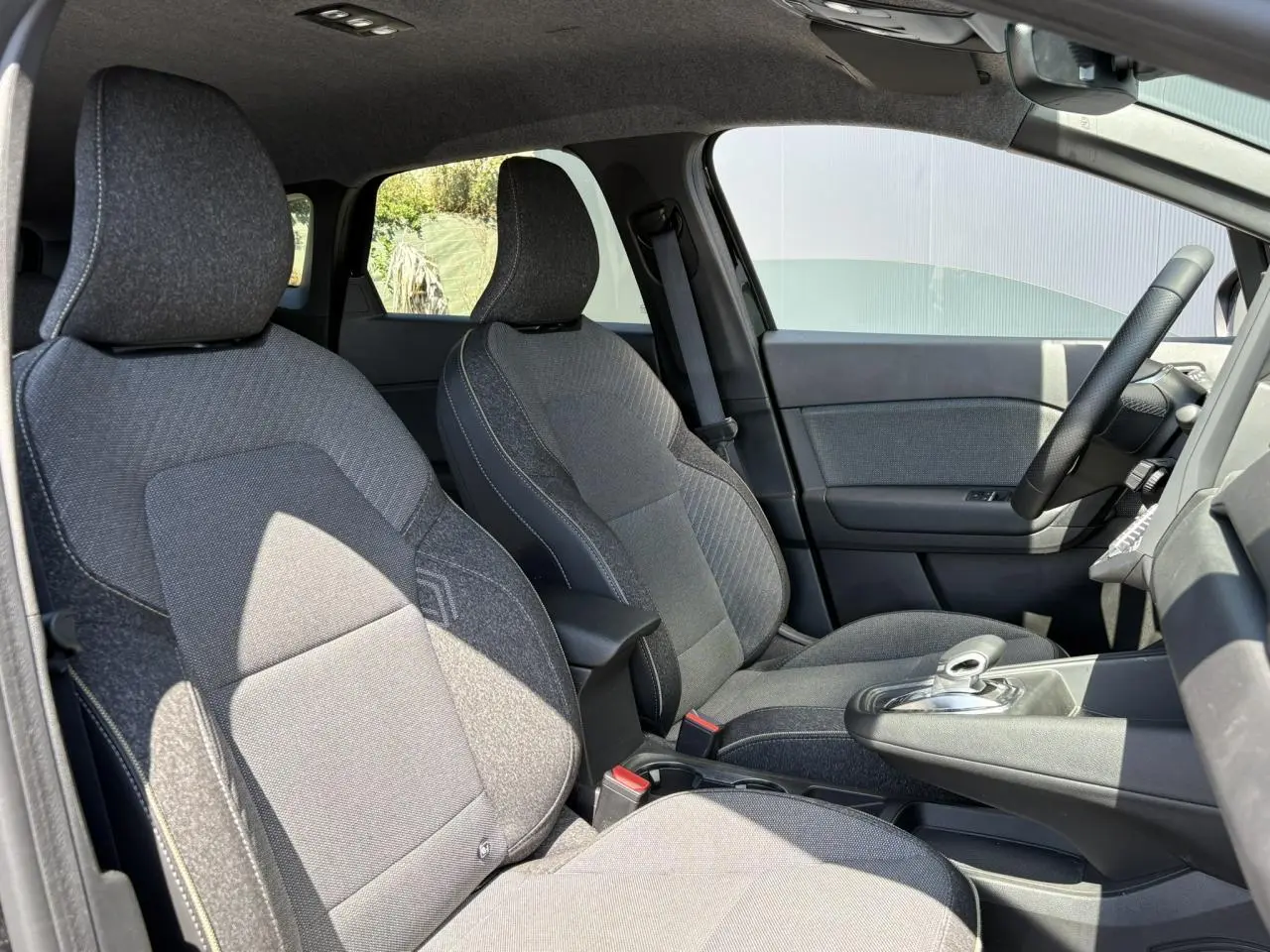 Intérieur de la Renault SYMBIOZ 2025, vue côté gauche sur les sièges avant gris foncé et volant noir.
