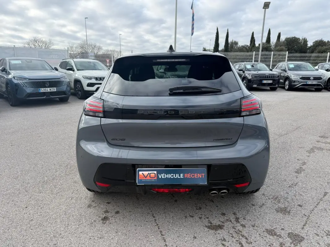 Vue arrière d'une Peugeot 208 Hybrid 145 gris métallisé, avec feux arrière LED et double sortie d'échappement visible.