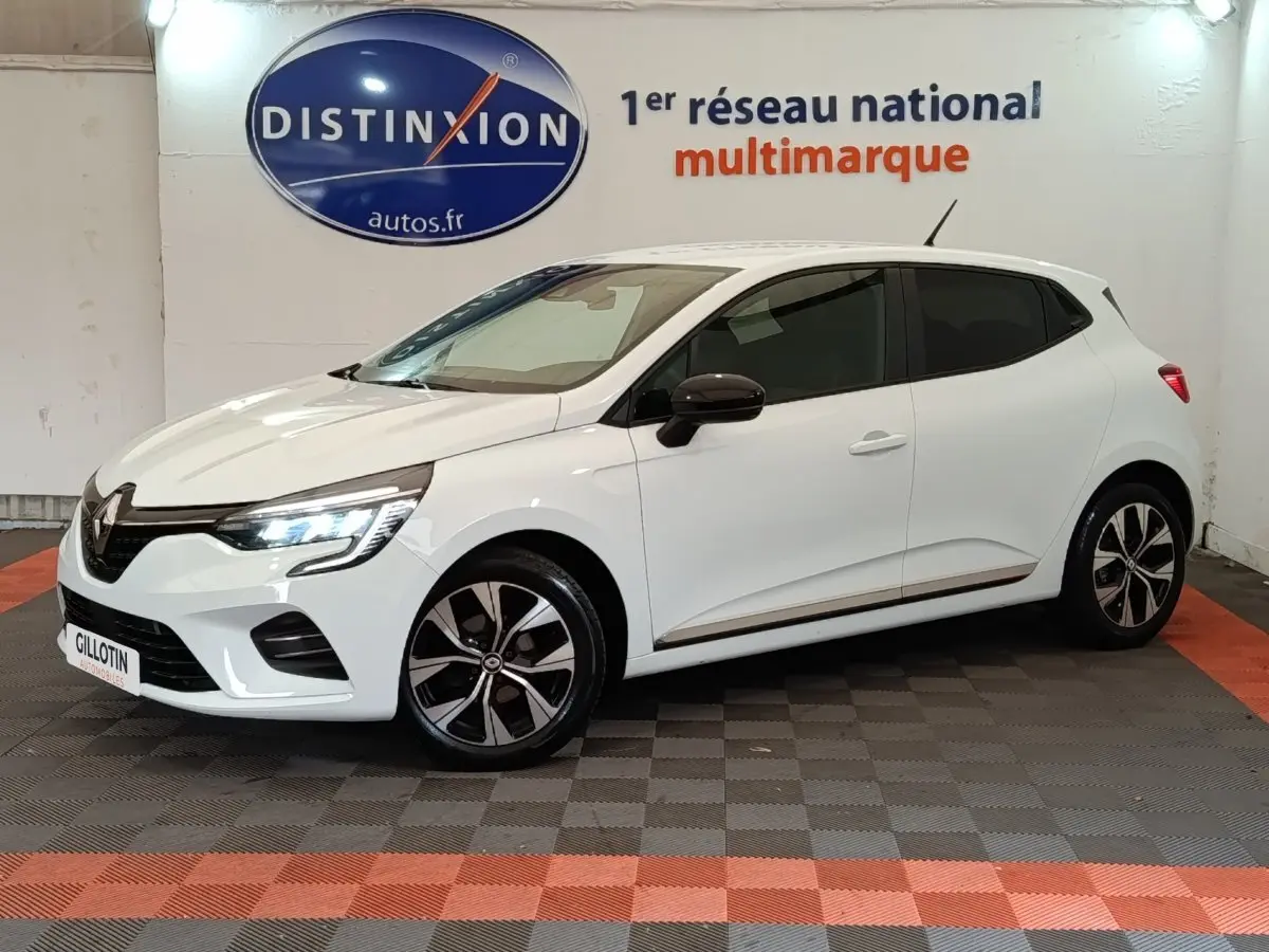 Renault Clio Evolution TCe 90 blanche vue en 3/4 avant droit, avec phares LED allumés et jantes noires bicolores.
