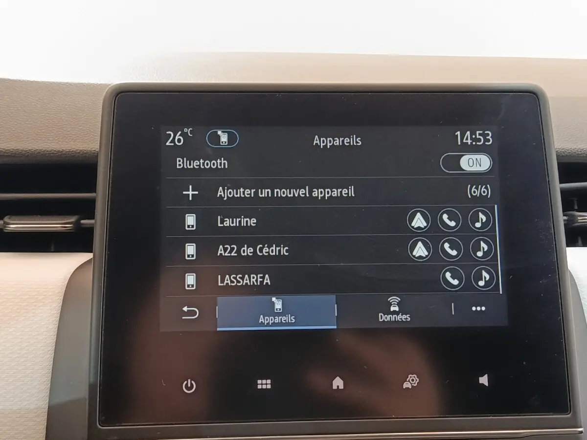 Écran tactile central de la Renault Clio blanc 2023 affichant la connexion Bluetooth et la liste des appareils.