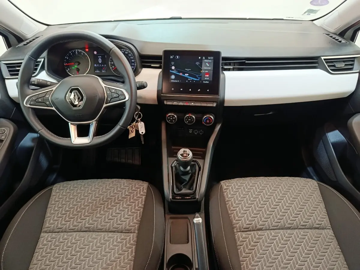 Vue intérieure avant de la Renault Clio Evolution TCe 90 2023 avec volant cuir multifonctions et écran tactile central.