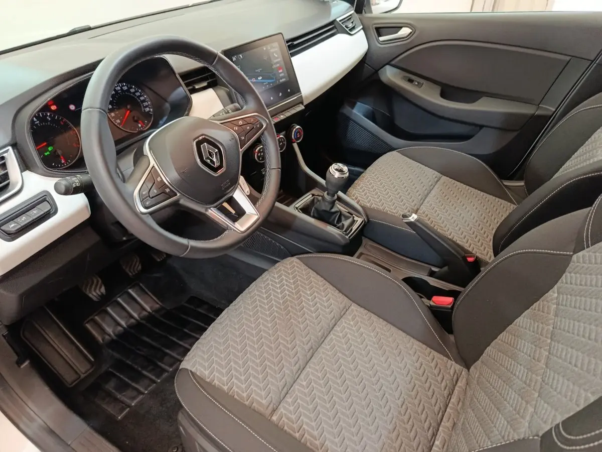 Intérieur de Renault Clio Evolution TCe 90 2023, vue côté conducteur, volant cuir multifonctions et écran tactile central.