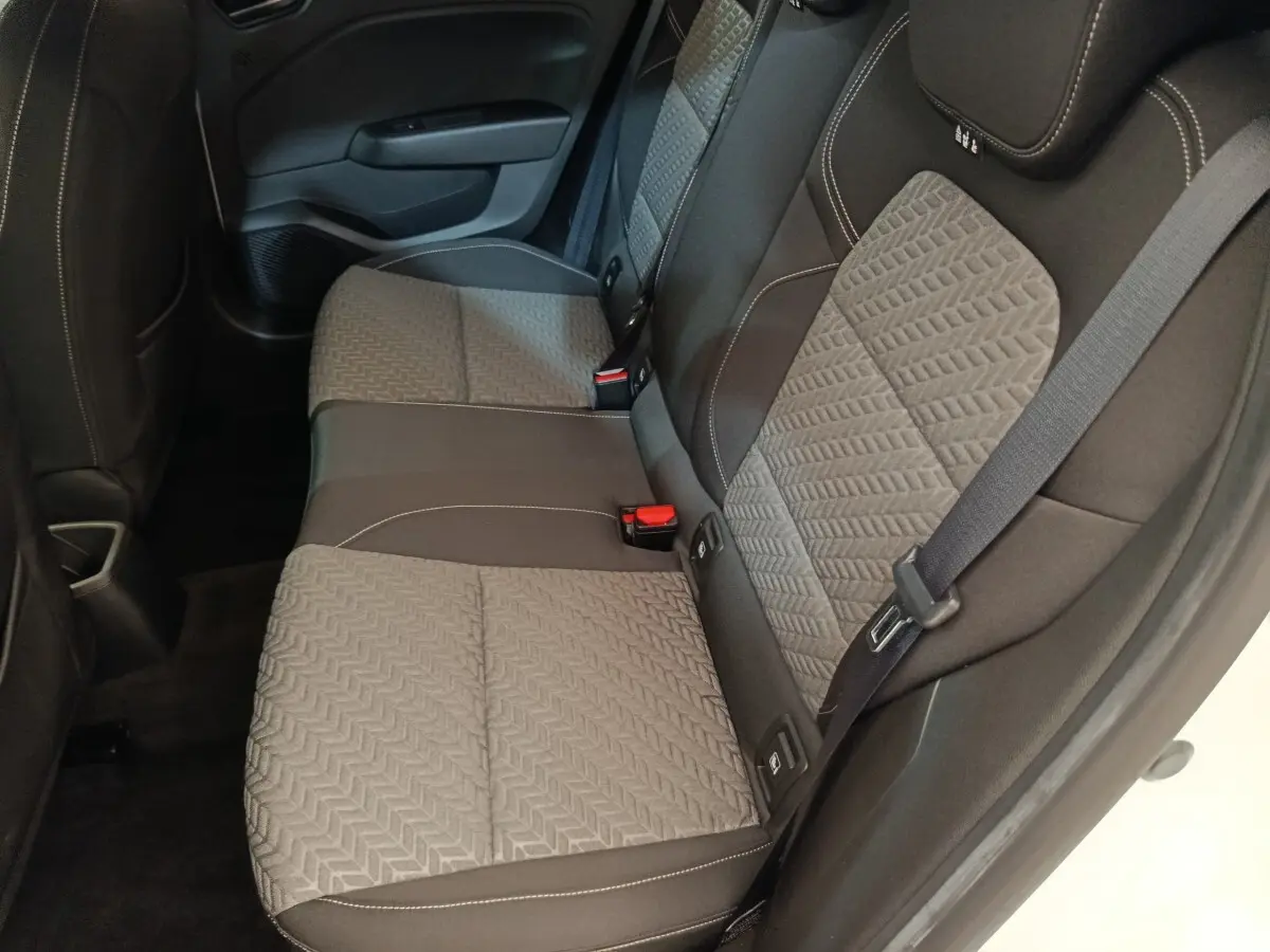 Vue latérale droite des sièges arrière gris et noirs de la Renault Clio Evolution TCe 90 2023, avec ceinture de sécurité visible.