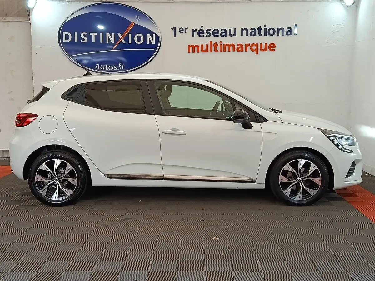 Profil gauche d'une Renault Clio Evolution TCe 90 blanche 2023 avec jantes alliage et rétroviseurs noirs.