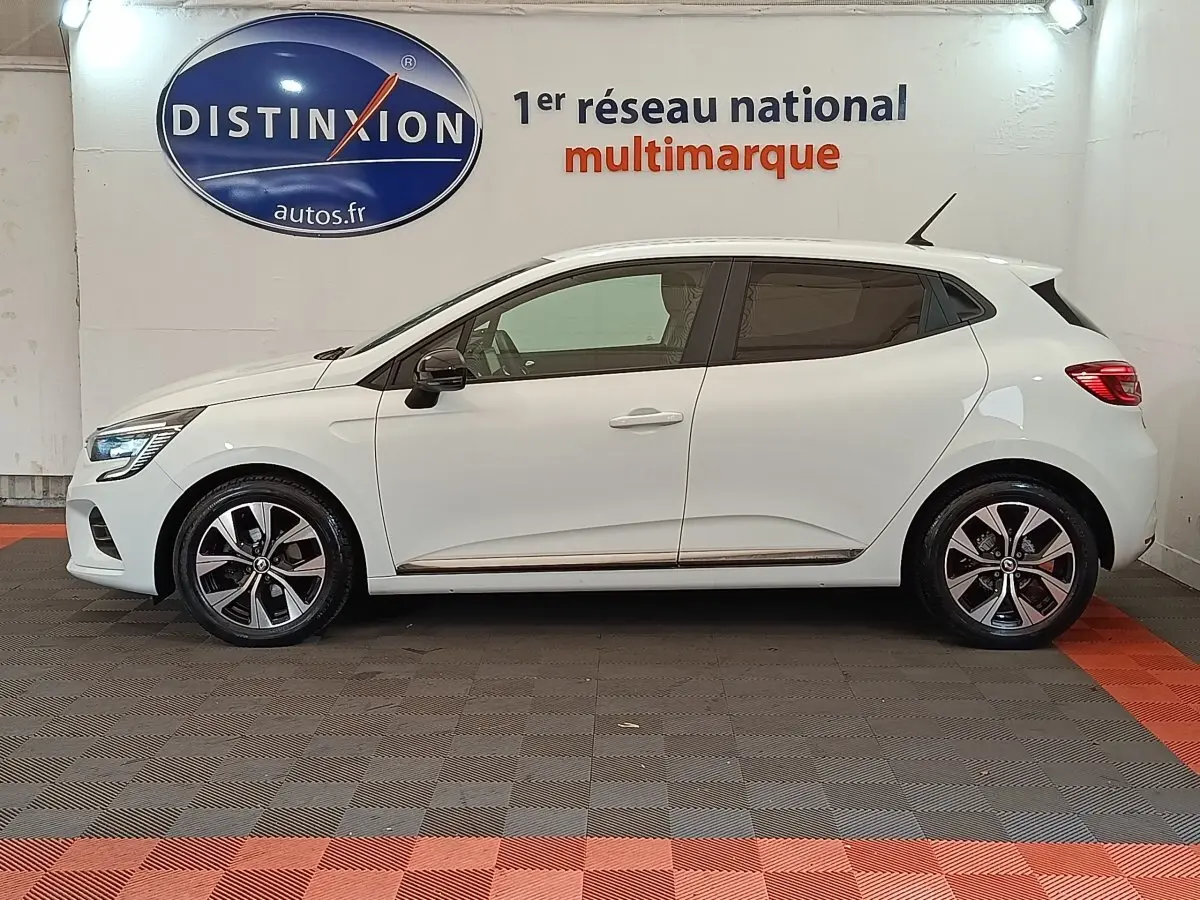 Profil droit d'une Renault Clio Evolution TCe 90 blanche 2023 avec jantes alliage et rétroviseurs noirs.