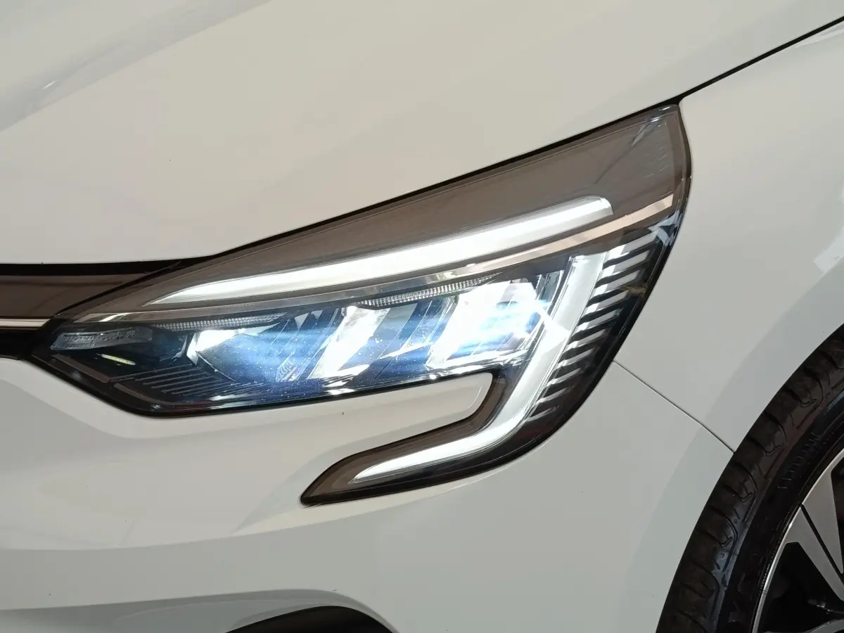 Gros plan sur le phare avant droit LED d'une Renault Clio Evolution TCe 90 blanche de 2023.
