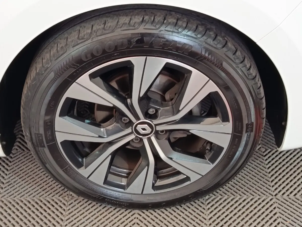 Gros plan sur la jante alliage noire et argentée d'une Renault Clio blanche, avec pneu Goodyear visible.