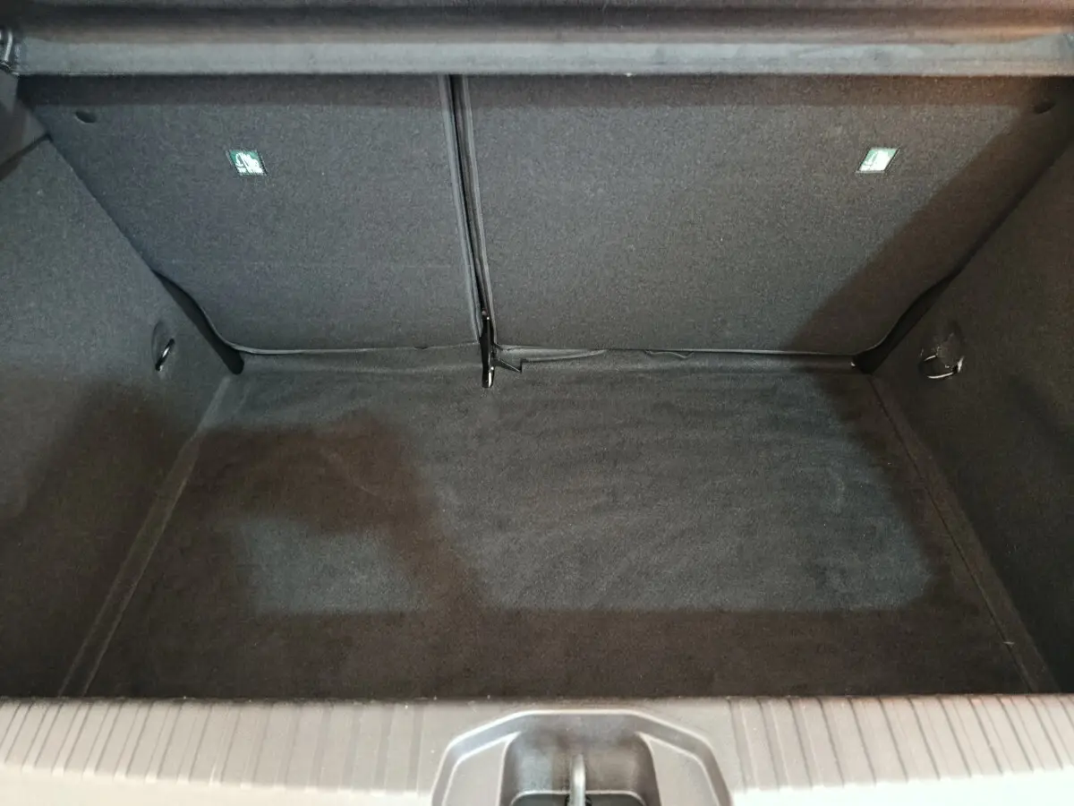 Coffre ouvert de la Renault Clio Evolution TCe 90 2023, vue intérieure, revêtement noir et banquette rabattue.