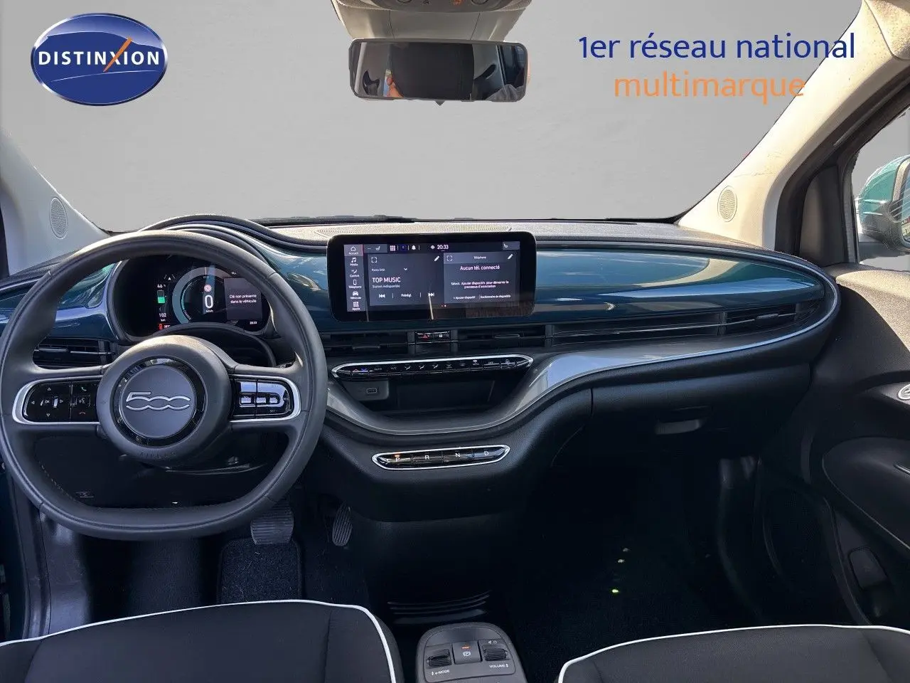 Intérieur de la Fiat 500 électrique 2023 vu de face, tableau de bord vert océan métallisé avec écran tactile central.