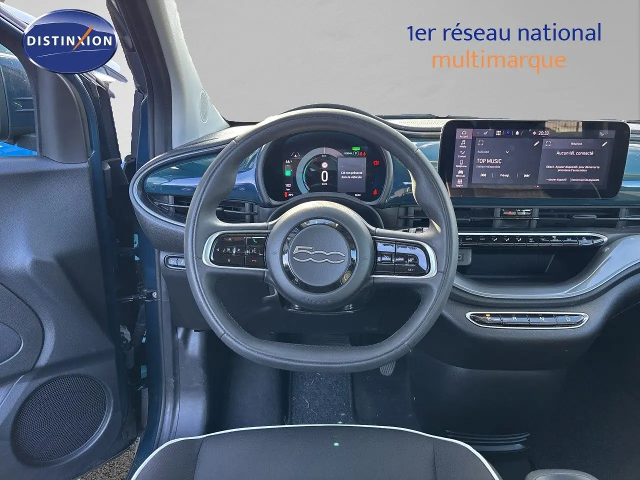 Vue intérieure centrée sur le volant et tableau de bord de la FIAT 500 électrique 2023, finition noir avec touches vert océan.