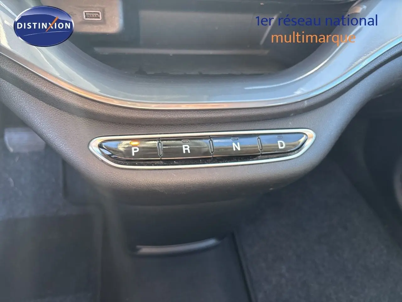 Gros plan sur la commande de boîte automatique avec boutons P, R, N, D allumée, intérieur noir de la Fiat 500 électrique 2023.