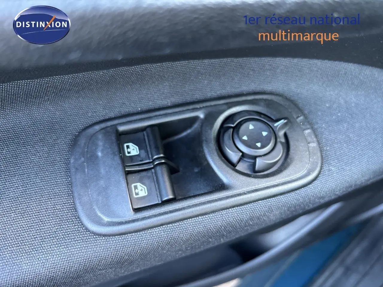 Gros plan sur les commandes de réglage des rétroviseurs et vitres côté conducteur d'une FIAT 500 électrique vert océan 2023.