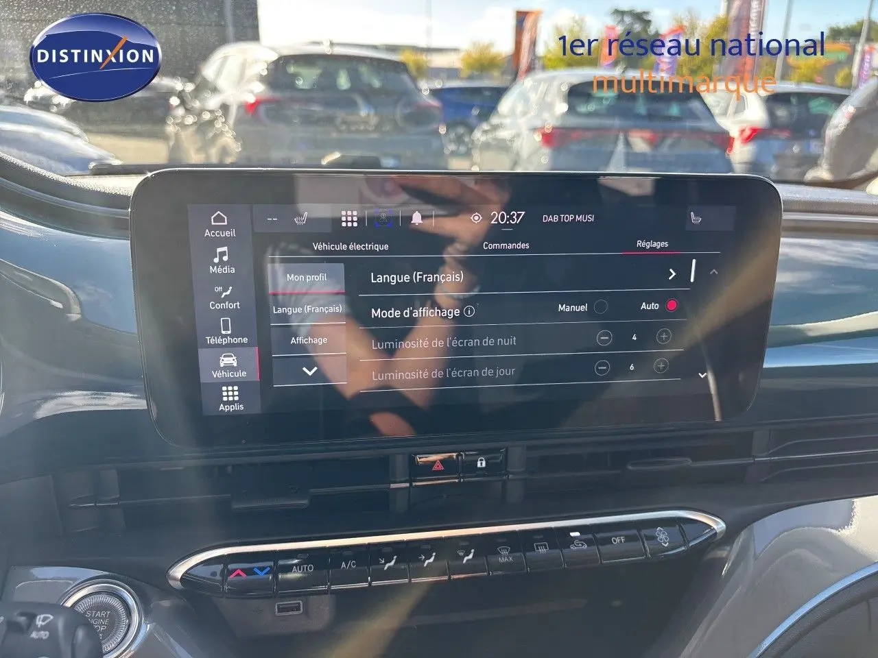 Vue rapprochée de l'écran tactile central du tableau de bord de la Fiat 500 électrique 2023, avec commandes climatisation visibles.
