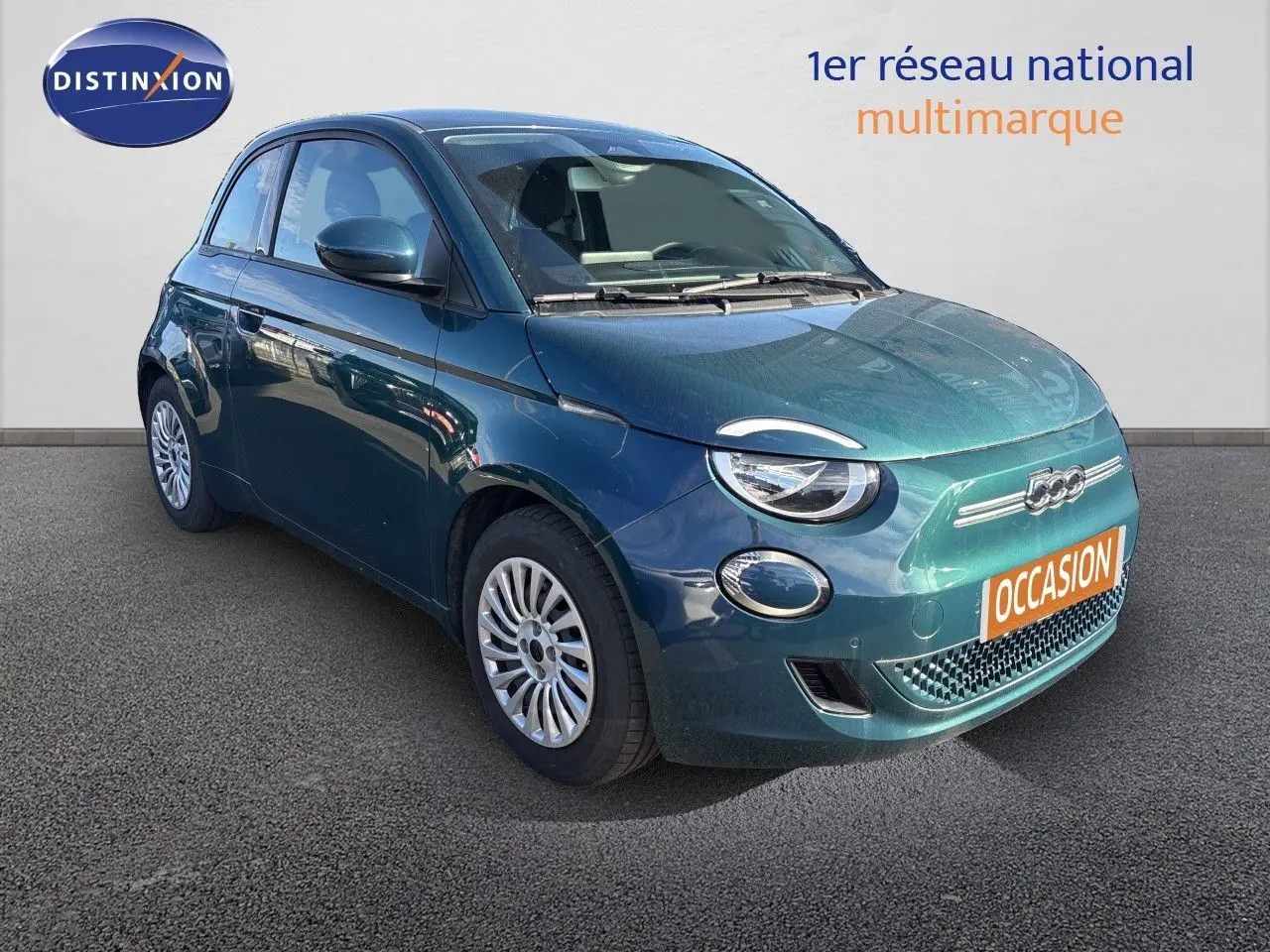 Vue 3/4 avant droite d'une Fiat 500 électrique 2023 en vert océan métal avec jantes argentées et calandre épurée.