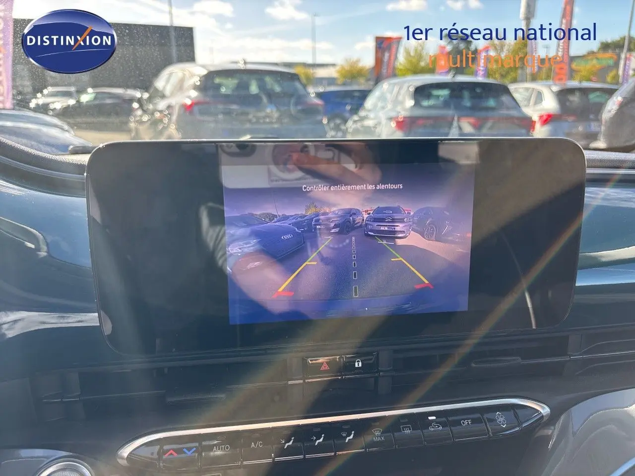 Écran tactile affichant la caméra de recul dans l’habitacle d’une Fiat 500 électrique vert océan, vue avant intérieure.