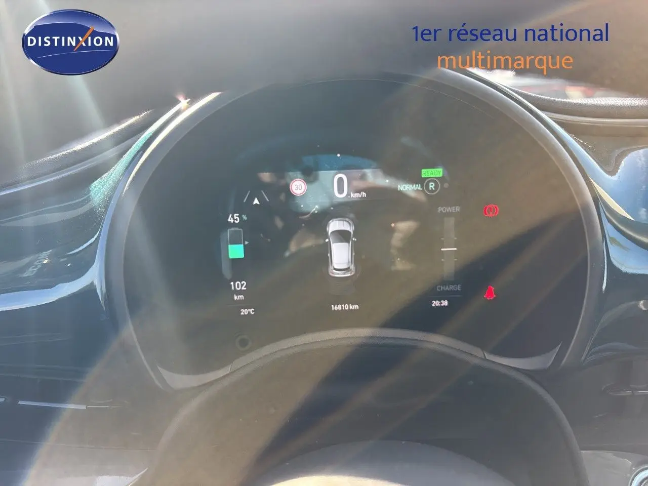 Vue rapprochée du tableau de bord numérique d'une Fiat 500 électrique 2023, affichant l'autonomie et la vitesse.