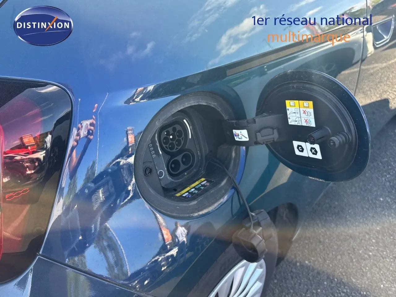 Prise de recharge électrique ouverte côté gauche d’une FIAT 500 Electrique 2023 vert océan métal, avec câble de charge visible.